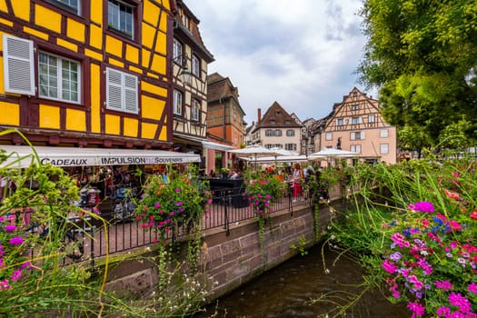 Colmar, France - July 27, 2018: Old town of Colmar, Alsace, France. View with colorful buildings, canal and flowers. Colmar, France. Petite Venice, water canal and traditional half timbered houses.