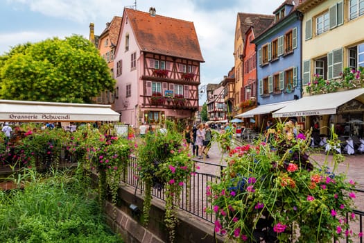 Colmar, France - July 27, 2018: Old town of Colmar, Alsace, France. View with colorful buildings, canal and flowers. Colmar, France. Petite Venice, water canal and traditional half timbered houses.