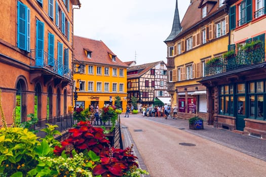 Colmar, France - July 27, 2018: Old town of Colmar, Alsace, France. View with colorful buildings, canal and flowers. Colmar, France. Petite Venice, water canal and traditional half timbered houses.
