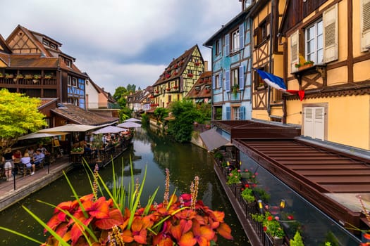 Colmar, France - July 27, 2018: Old town of Colmar, Alsace, France. View with colorful buildings, canal and flowers. Colmar, France. Petite Venice, water canal and traditional half timbered houses.