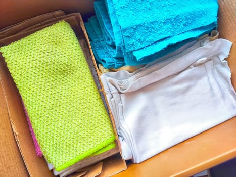 Old rags and eco-friendly cleaning cloths neatly arranged in a cardboard box. Old rags and things for cleaning and cleanliness in the house. Eco-friendly use of recyclables