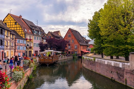 Colmar, France - July 27, 2018: Old town of Colmar, Alsace, France. View with colorful buildings, canal and flowers. Colmar, France. Petite Venice, water canal and traditional half timbered houses.