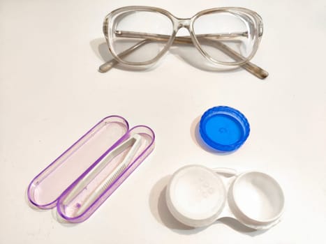 Set for contact lenses with a container, forceps, glasses. The concept of correcting myopia. Contact lens care, cleaning, health. Background, copy space