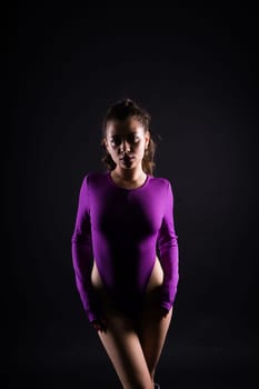 Seductive young female in violet bodysuit on a dark and red background