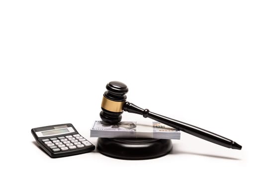 An isolated image of a judge's gavel on a stack of cash with a calculator, signifying legal fines or bail