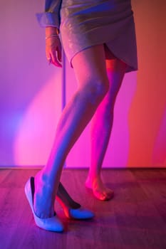 Woman legs closeup in stokings with neon color background