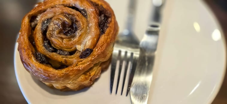 delicious freshly baked Cinnamon rolls or cinnamon bun, with raisins and vanilla also icing sugar ridiculously good pastry