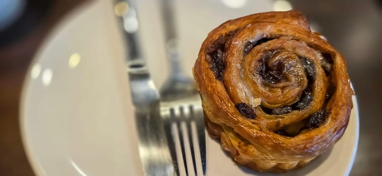 delicious freshly baked Cinnamon rolls or cinnamon bun, with raisins and vanilla also icing sugar ridiculously good pastry