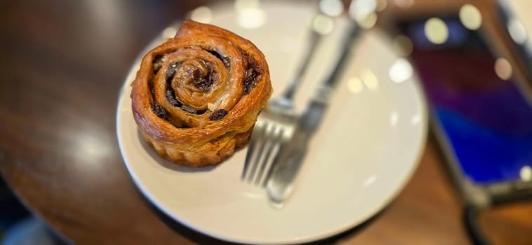 delicious freshly baked Cinnamon rolls or cinnamon bun, with raisins and vanilla also icing sugar ridiculously good pastry