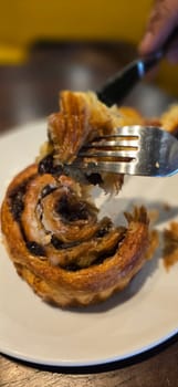delicious freshly baked Cinnamon rolls or cinnamon bun, with raisins and vanilla also icing sugar ridiculously good pastry