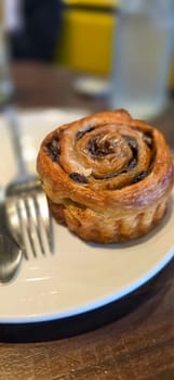 delicious freshly baked Cinnamon rolls or cinnamon bun, with raisins and vanilla also icing sugar ridiculously good pastry