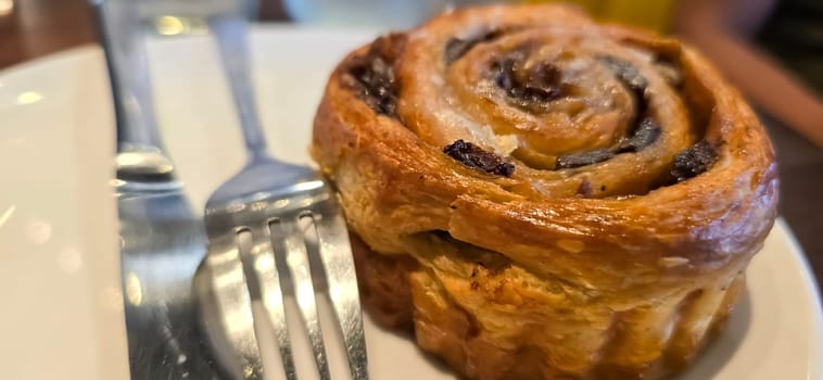 delicious freshly baked Cinnamon rolls or cinnamon bun, with raisins and vanilla also icing sugar ridiculously good pastry