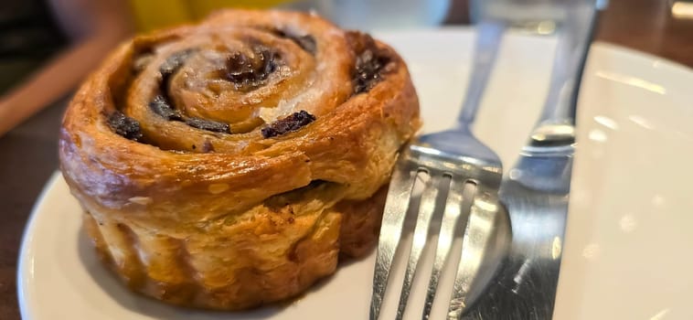 delicious freshly baked Cinnamon rolls or cinnamon bun, with raisins and vanilla also icing sugar ridiculously good pastry