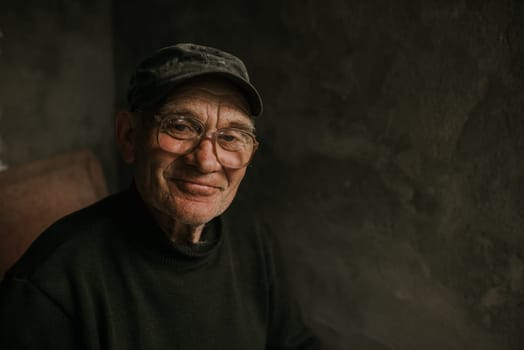 Pensive old man in glasses with gray hair looks away. wrinkles. wisdom. against a dark gray texture wall. bald head. in a knitted sweater. Portrait.