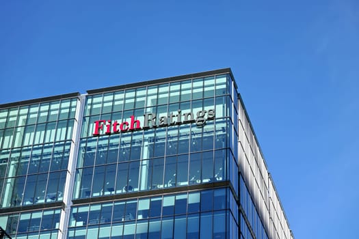 London, United Kingdom - February 03, 2019: Fitch Ratings logo signage at top of their Headquarters in UK (other is in New York), Canary Wharf. FR is one of the Big Three credit rating agencies