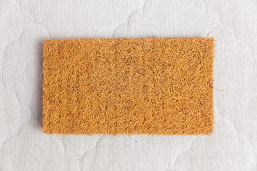 A rectangular sample of coconut coir used in the production of modern mattresses with independent spring blocks. Top view.
