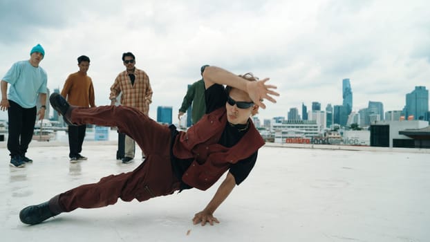 Professional asian street dancer practice B boy dance while multicultural friends at roof top. Young modern dancing group doing hip hop movement. Style,fashion,action. Outdoor sport 2024. Endeavor.