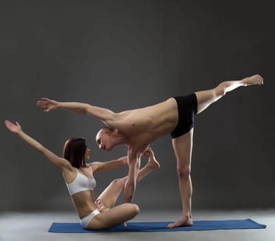 Paired yoga. Image of instructors posing in complex asana