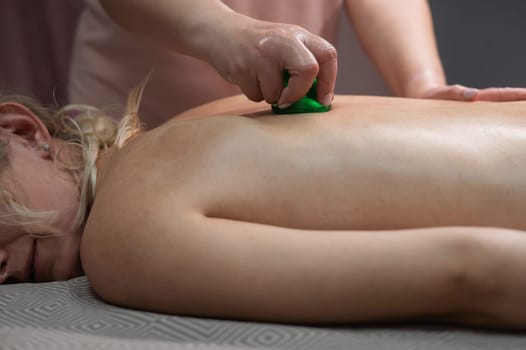 A woman undergoing a massage using vacuum plastic jars