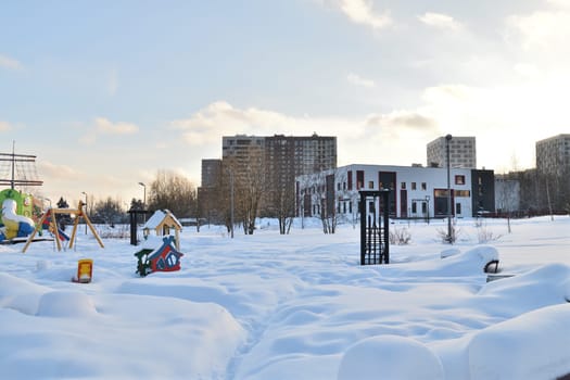 Moscow, Russia - Feb 19. 2024. Cityscape with playground covered in snow