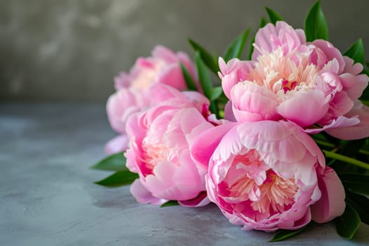 A bunch of pink peonies sitting on top of a table, adding a pop of color to the room.