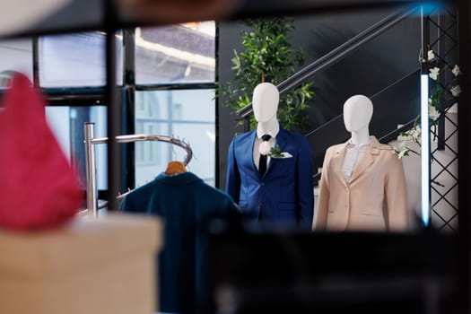 Shopping centre filled with new fashion collection, multiple racks with stylish casual wear and elegant accessories. Empty clothing showroom with fashionable shirts on hangers, small business concept.