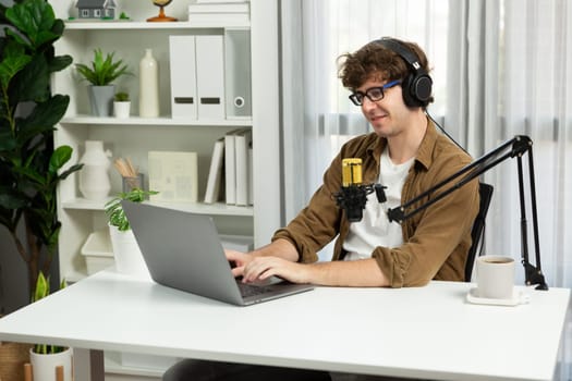 Host channel of influencer searching information for answering to listeners on social media with laptop in life coaching. Concept of radio online lifestyles at cozy studio modern home office. Gusher.