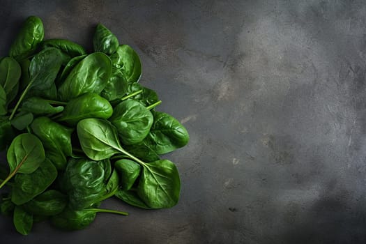 Fresh spinach leaves on a dark textured background.