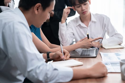 Professional Asian employee work together as team in corporate office, discussing business plans and data to achieve success on desk with laptop. Modern office worker teamwork concept. Concord