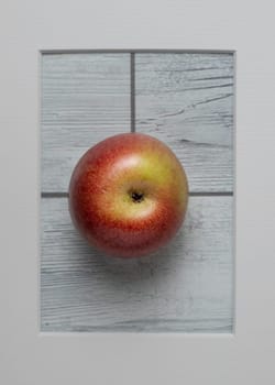 Annurca apple in frame on white wooden background