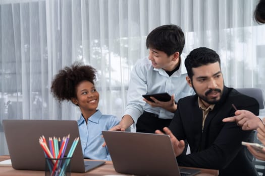 Happy diverse business people work together, discussing in corporate office. Professional and diversity teamwork discuss business plan on desk with laptop. Modern multicultural office worker. Concord