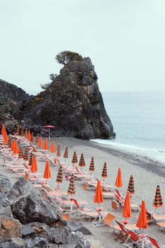 Seaside lido with closed umbrellas on Palinuro beach to indicate a tourism concept. High quality photo