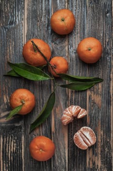 A composition of mandarins on wooden background. Mandarin slices. Mandarin with leaves