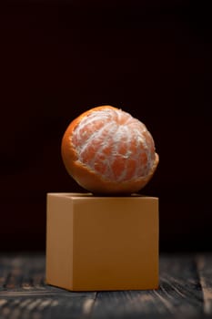 One peeled tangerine isolated with space on a black background