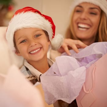 Christmas, sofa and portrait of child with gift, mom and celebration together with happy surprise. Holiday, mother and son smile on couch for present giving, festive xmas and love in family home