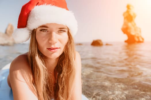 Close up shot of happy young caucasian woman looking at camera and smiling. Cute woman portrait in bikini posing on a volcanic rock high above the sea