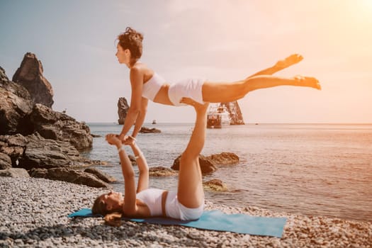 Woman sea yoga. Back view of free calm happy satisfied woman with long hair standing on top rock with yoga position against of sky by the sea. Healthy lifestyle outdoors in nature, fitness concept.