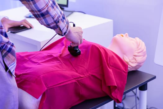 A man tries ultrasound on a mannequin at a health care expo. High quality photo