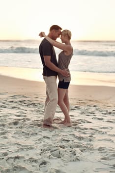 Couple, together and beach with sunset for romance with peace in trip and vacation. Partners, embrace and relax in sea to enjoy, calm and smile for love of marriage in honeymoon and holiday.