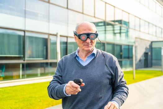 Smiling elder businessman using an augmented reality device outside the financial building