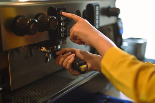 Close up barista using modern coffee machine, preparing coffee for customer in cafe.