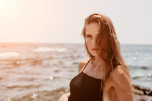 Woman travel sea. Young Happy woman in a long red dress posing on a beach near the sea on background of volcanic rocks, like in Iceland, sharing travel adventure journey