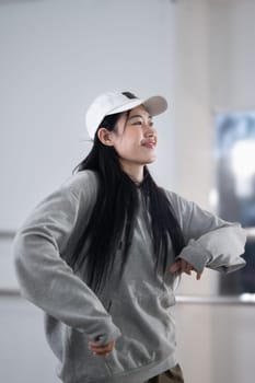 Beautiful female hip hop dancer in hoodie practicing at her studio.