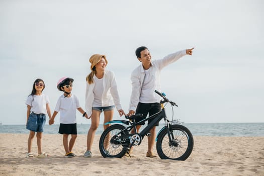 Parents and children walking on the beach pushing bicycles a full-length family scene of happiness joy and the carefree spirit of childhood enjoying the sun and sea. Family on beach vacation