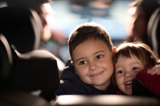 A young brother and sister enjoying a car ride together, immersed in the adventure of travel.