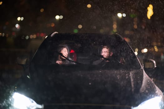 In the midst of a nighttime journey, a happy family enjoys playful moments inside a car as they travel through rainy weather, illuminated by the glow of headlights, laughter, and bonding.