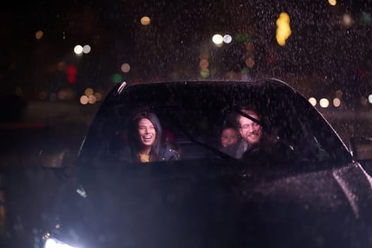 In the midst of a nighttime journey, a happy family enjoys playful moments inside a car as they travel through rainy weather, illuminated by the glow of headlights, laughter, and bonding.