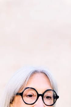 detail of the eyes of an unrecognizable senior woman with glasses, concept of happiness of elderly people and active lifestyle, copy space for text