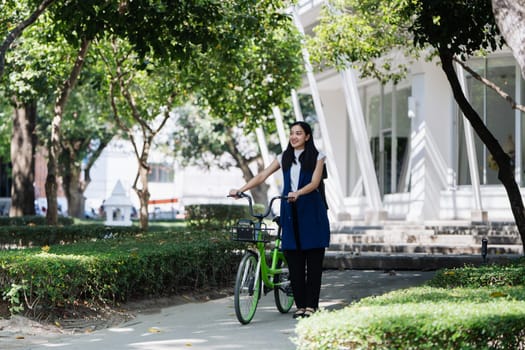 Professional Business woman with bike in the morning walking in the street to work. Eco friendly.