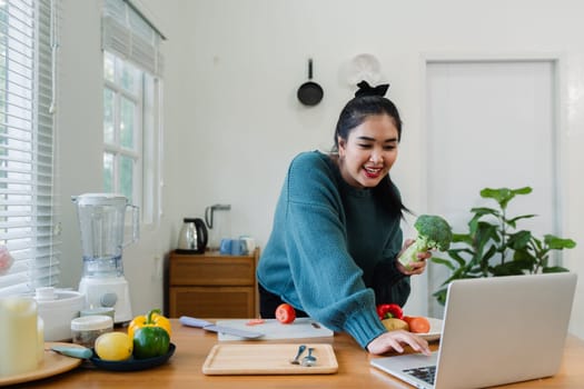 overweight Asian woman learning to make salad and healthy food from social media.
